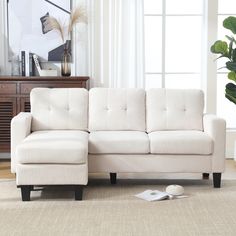 a white couch sitting on top of a rug next to a window