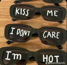 four pairs of sunglasses with the words i don't care and kiss me written on them