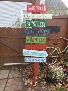 a pole that has some signs on it in front of a fence and a bike