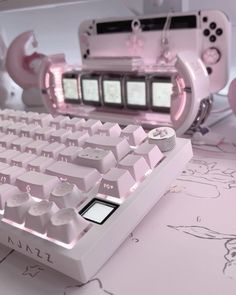 a pink computer keyboard sitting on top of a desk next to a mouse and game controller