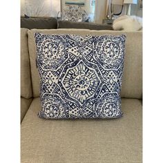 a blue and white pillow sitting on top of a couch