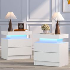 two white nightstands with blue lights on each side and a lamp next to them