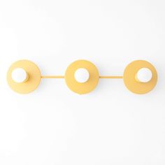 three yellow circles hanging on a white wall