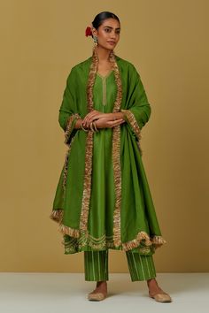 Green kurta with floral embroidery and V neck. Paired with sequin work pant and tissue organza fringe dupatta.
Components:3
Pattern:Embroidered
Type of Work:Floral
Neckline:V Neck
Sleeve Type:Flared
Fabric:Chanderi Silk, Tissue Organza
Color:Green
Other Details:
Floral and sequin work
Occasion:Puja - Aza Fashions V Neck Kurta, Chanderi Silk Suits, Latest Dress Design, Pakistani Designer Suits, Casual Indian Fashion, Silk Kurta, Dupatta Set, Embroidery Suits Design, Green Hand