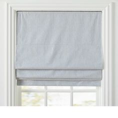 a blue and white striped roman blind in front of a window