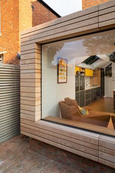 the reflection of an open kitchen and living room in a glass doored window on a brick building