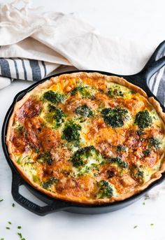 a quiche with broccoli and cheese in a cast iron skillet