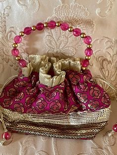 Banarsi Pink Pure Potli Bag. Gold hand crafted evening Bad. Pink Beaded Handles Gold Tassel Closure Ornate with Gold laces. Preowned Excellent Condition By Gharonda Elegant Pink Shoulder Bag For Festivals, Elegant Pink Handmade Potli Bag, Elegant Pink Shoulder Bag For Festive Occasions, Traditional Pink Shoulder Bag For Evening, Pink Shoulder Bag With Handwork For Party, Handmade Handheld Evening Bag For Festive Occasions, Pink Bags For Evening And Festivals, Handmade Potli Bag For Party And Festivals, Elegant Pink Potli Bag For Festivals