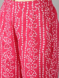 Fuschia Pink Bhandej Print Shirt with Black Bhandej Side Tie Up Paired with Statement Bottoms Fuschia pink cotton bhandej shirt kurta with pant set. Super trendy yet comfy. Black bhandej waist tie up give it a show-stopper look . Elastic waistband with lace detailing on the pant hem. Product doesn't have liningCold wash and Dry clean onlyLining Material: No lining Pattern: Bhandej Print Fit: Relaxed Model Height: The model (height 5'9", Chest 34", Waist 28", Hip 38") is wearing Size Small Measur Summer Bandhani Print Sets With Straight Kurta, Bandhani Print Straight Kurta Sets For Summer, Pink Cotton Palazzo Set For Festivals, Pink Cotton Sets For Diwali, Bollywood Style Pink Cotton Palazzo Set, Pink Cotton Sets With Printed Motifs, Cotton Bandhani Print Sets For Spring, Pink Block Print Palazzo Set For Diwali, Pink Anarkali Cotton Palazzo Set