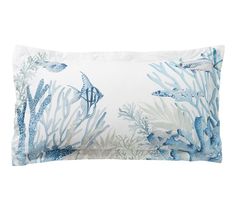 a blue and white pillow with sea life on the front, along with corals and fish