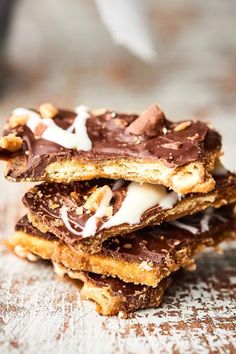 three pieces of chocolate covered pretzels stacked on top of each other with white icing