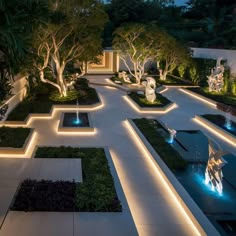 an outdoor garden at night with lights on the ground and trees in the center, surrounded by greenery