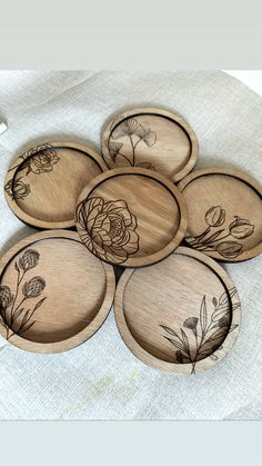 six wooden plates with floral designs on them