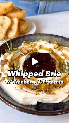 whipped brie with cranberry and pistachio sauce on a black plate