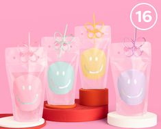 four plastic cups with smiley faces on them and one has a bow in the middle