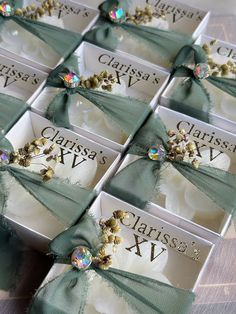 six cards with green bows on them are sitting in a box, each one has a diamond brooch