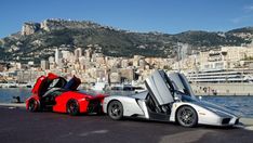 a silver and red sports car parked in front of a large body of water