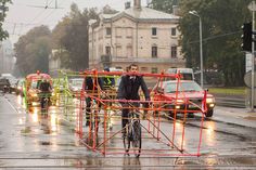 a man riding a bike down a street next to scaffolding on the road