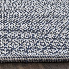 a blue and white rug on top of a wooden floor