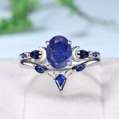 a ring with blue sapphire stones and leaves on the sides, set in white gold