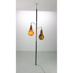 two lamps that are sitting on top of a pole in the middle of a room