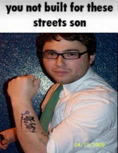 a man wearing glasses and a tie with tattoos on his arm