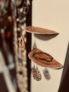 several necklaces are hanging on the side of a wall with jewelry attached to it