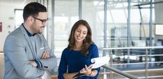 a man and woman looking at something on a clipboard