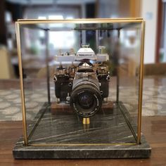 an old fashioned camera in a glass case