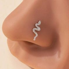 the side view of a woman's nose with a diamond earring on it