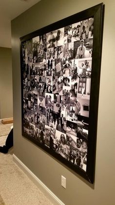 a black and white photo hanging on the side of a wall next to a cat