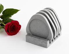 a red rose sitting next to a stack of plates