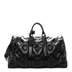 This is an authentic LOUIS VUITTON Lambskin Monogram Keepall Puffer XL Bandouliere 75 in Black. This stylish travel duffel is crafted of signature Louis Vuitton monogram lambskin in black. This bag features rolled top handles, an optional adjustable shoulder strap, and matte black hardware. The top zippers open to a spacious black fabric interior with a pocket. Luxury Duffel Bag, Louis Vuitton Puffer Bag, Duffle Bag Louis Vuitton, Louis Vuitton Black Keepall, Louis Vuitton Duffle Bag Travel, Luxury Bags With Monogram Print, Luv Bag, Burberry Luggage, Lv Travel Bag