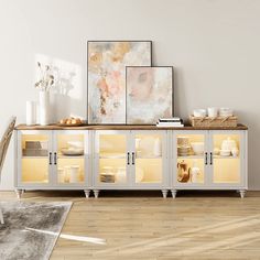 a white cabinet with glass doors and shelves in the middle of a wooden floored room