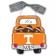 an orange vw bus with footballs in the back and a bow on top