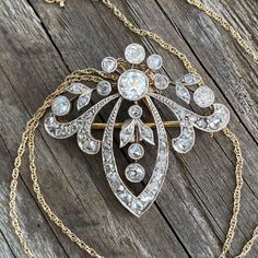 "Details: Edwardian Belle Époque diamond pendant from the early 1900's. There is a count of 50 diamonds, the largest being 5mm close to 1/2 carat. There are 5 large bezel set Old European Cut diamonds and the balance are bead set and bezel set rose cut diamonds. Mille grain work on all edges is meticulously finished. The center five diamonds move independently of the surround. A very pretty piece in excellent condition. The gold pendant tests at 18K and the 16\" modern chain is 14K gold. The pin Vintage Yellow Gold Diamond Necklace, Vintage Pendant Necklace With Brilliant Cut, Antique White Gold Diamond Necklace, Antique White Gold Diamond Pendant Necklace, Vintage Formal Diamond Necklace With Single Cut Diamonds, Antique White Gold Diamond Necklace With Single Cut Diamonds, Vintage Yellow Gold Diamond Necklace For Formal Occasions, Heirloom Diamond Necklace With Intricate Design, Victorian Gold Diamond Brooches