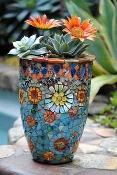 a potted plant sitting on top of a stone wall next to a swimming pool