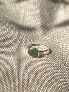 Handmade sterling silver Sea glass ring, made with recycled silver, and genuine Sea glass from the jurassic coast.  This ring has one small piece of green sea glass, and is very dainty and elegant. The ring is also stackable, especially with the other sea glass rings i have listed! This ring is a perfect gift for special occasions, and for Sea glass lovers!  The ring is size UK Q 1/2 .  All of the silver on the ring is 925 Sterling Silver, including the band! Feel free to message me for any additional information, or for commissions/custom requests! Silver Recycled Glass Ring, Adjustable Silver Ring With Sea Glass, Green Sterling Silver Stackable Jewelry, Green Sterling Silver Minimalist Ring, Nickel-free Round Recycled Glass Jewelry, Green Minimalist Sterling Silver Ring, Adjustable Green Nickel-free Ring, Handmade Sea Glass Ring Jewelry, Adjustable Sea Glass Ring Jewelry