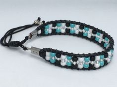 - 7" bracelet adjusts up to 7.5" - Strung on leather with beading string, strap and slip knot are made with nylon cord. - Easy on/off closure - Toho glass beads including turquoise blue, silver lined clear, white and matte black Strung on leather with nylon cord. - Stainless Steel cord ends. - Measures 7" from end of cord ends, cord ends are .5" each, straps are approximately 3" each side, the slip knot is approximately 5/16" wide. - If you would like to shorten the length of the strap you can k Adjustable Beaded Turquoise Leather Bracelet, Adjustable Hand-strung Leather Bracelet With Round Beads, Adjustable Turquoise Beaded Leather Bracelet, Adjustable Beaded Leather Bracelet For Friendship, Handmade Adjustable White Leather Bracelet, White Handmade Adjustable Leather Bracelet, Adjustable Handmade White Leather Bracelet, Handmade White Leather Adjustable Bracelet, Turquoise Adjustable Cord Friendship Bracelets