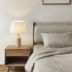 a bed with two nightstands and a lamp on the side table next to it