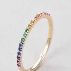 a yellow gold ring with multi colored stones