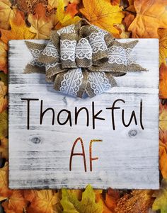 a wooden sign that says, thank af with an image of a bow on it