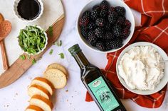 an assortment of food including bread, cream cheese and berries