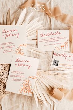 three wedding stationery cards on top of a white table cloth with brown and orange designs