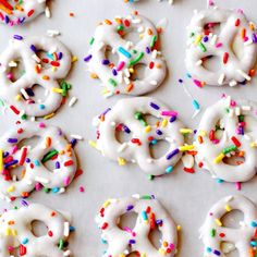 six donuts with white frosting and sprinkles