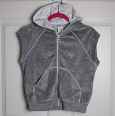 Description: new with tags vintage 90s/00s/y2k-era Self Esteem grey velour tracksuit sleeveless hoodie (ONLY--NO pants), multicolor rhinestone heart on front, white trim, satin-lined hood, split kangaroo pocket front, size large juniors. *Please note that clothing from this era is priced higher than original MSRP due to demand. Details/Measurements fabric: 80% cotton/20% polyester underarm to underarm - 20" length in back, neck to hem - 20" Customer satisfaction is my priority, so please read be Hooded Athleisure Vest For Streetwear, Sporty Stretch Hooded Vest, Fitted Hooded Vest For Streetwear, Fitted Y2k Hoodie, Velour Tracksuit, Y2k Era, Hoodie Vest, Sleeveless Hoodie, Aesthetic Look