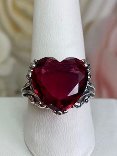 Red Heart Gem Sterling Silver RingHeart Leaf Design#D213 This Gothic inspired lovely filigree ring is set with a 10ct flawless red gemstone. This heart gemstone is 15mm x 15mm. The rings sits 11mm off the finger. Notice the beautiful gothic design of the silver filigree setting and band. The inside of the band is marked 925 for sterling silver. This is an exquisite rendition of an antique filigree ring. The sterling filigree cradles the stone in a delicate caress. Classic and beautiful, this vin Garnet Heart Ring, Red Gem Jewelry, Red Round Jewelry For Valentine's Day, Heart Shaped Wedding Jewelry, Heart-shaped Wedding Jewelry, Formal Red Heart Cut Rings, Heart-shaped Wedding Jewelry With Jewels, Formal Red Heart Cut Ruby Ring, Red Heart Cut Rings For Formal Occasions