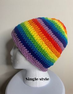 a white mannequin head wearing a multicolored knitted beanie hat