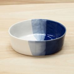 a blue and white bowl sitting on top of a wooden table