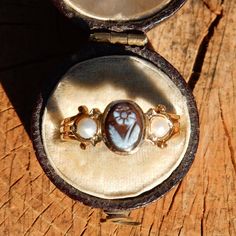 Pretty 18ct ladies mourning ring, set with a hard stone (prob agate) flower cameo to centre with a pearl each side. The cameo is approx 7 x 5 mm and the pearls are approx 2.75mm (half pearls). The finger size is (UK) L for London, the ring is not marked but tests as 18ct gold, total wgt 2.7gms. The ring box in the photos is NOT included, but it will come in a nice ring box. Thank you for looking, and please view my other antique jewellery  items. Victorian Cabochon Pearl Ring As Gift, Victorian Cabochon Pearl Ring Gift, Victorian Style Cabochon Pearl Ring Gift, Antique Cameo Jewelry, Victorian Wedding Ring, Rose Diamond Ring, Memorial Ring, Cameo Jewelry, Gold Signet Ring